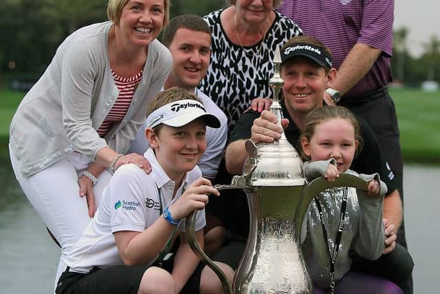 Stephen Gallacher celebrates with his family - wife Helen, nephew Chris, mum Wilma and dad Jim in back row and son Jack and daughter Ellie at the front - after creating history by becoming the first player to successfully defend the Omega Dubai Desert Classic title in 2014 at Emirates Golf Club. Picture: Marwan Naamani/AFP via Getty Images.