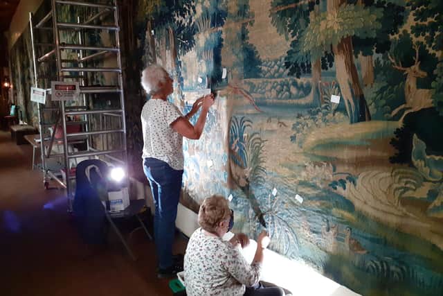 Volunteers at work on the 400-year-old tapestry at Falkland Palace. PIC: NTS