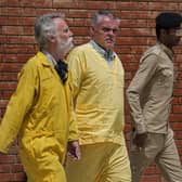 Jim Fitton of Britain, left, and Volker Waldman  escorted by Iraqi security forces, outside a courtroom, in Baghdad