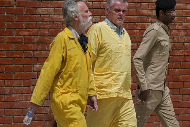 Jim Fitton of Britain, left, and Volker Waldman  escorted by Iraqi security forces, outside a courtroom, in Baghdad