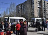 People wait to board buses during their evacuation in Kramatorsk, Ukraine, Saturday, April 9, 2022. After the bombing of the train station Friday, resident are continuing their attempts to leave the city on buses and other transports. (AP Photo/Andriy Andriyenko)
