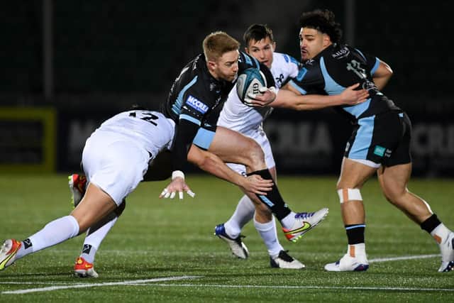 Glasgow's Kyle Steyn (centre) is tackled by Ospreys Owen Watkin.