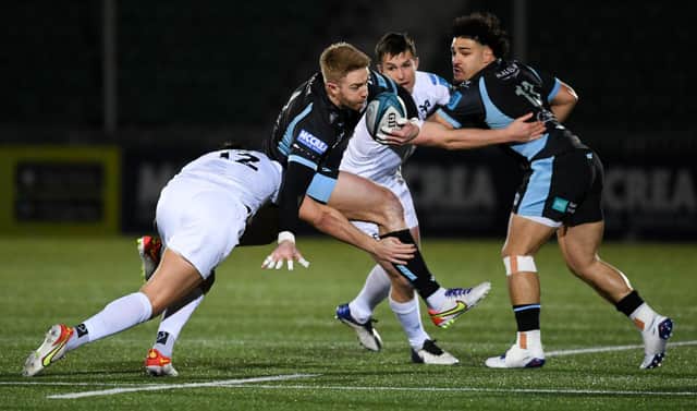 Glasgow's Kyle Steyn (centre) is tackled by Ospreys Owen Watkin.