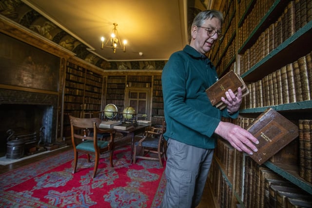Guide Iain MacLeod shelves books in the First Library which was compiled between 1700-1740 with over 3000 books.