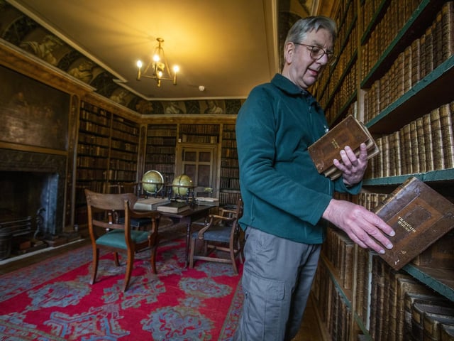 Guide Iain MacLeod shelves books in the First Library which was compiled between 1700-1740 with over 3000 books.