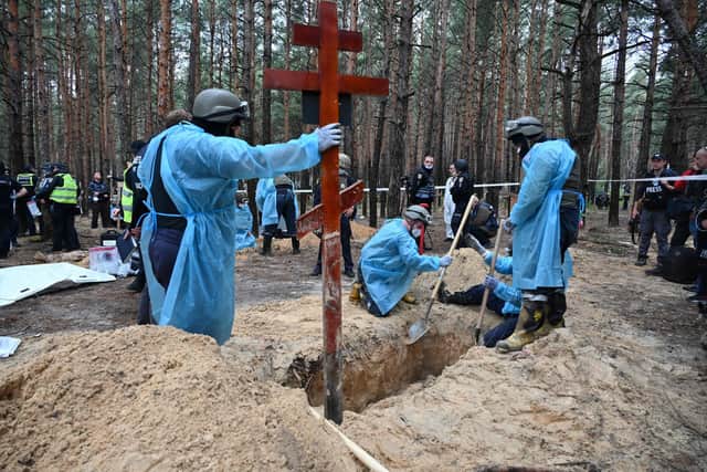 Forensic technicians dig a grave in a forest on the outskirts of Izyum in eastern Ukraine. Picture: Sergey Bobok/AFP via Getty Images