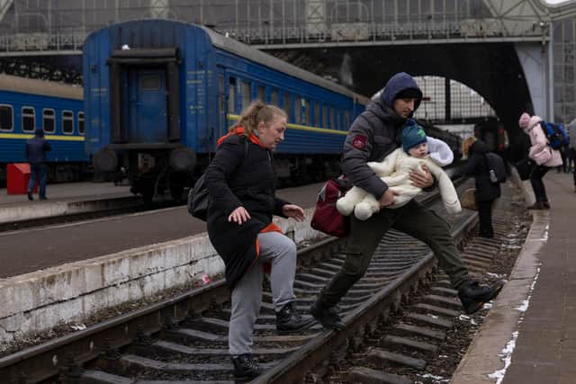 A family crosses a railway line in Lviv, Ukraine as refugees flee the Russian offensive (Picture: Dan Kitwood/Getty Images)