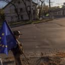 Children with an European flag wave to cars driving past in the southern Ukrainian city of Kherson.