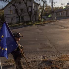 Children with an European flag wave to cars driving past in the southern Ukrainian city of Kherson.