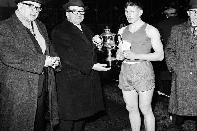 Mr J Harris presents the cup to D Hendrie, the winner of the youth 100 yards handicap at the Powderhall New Year Sprint in 1965.