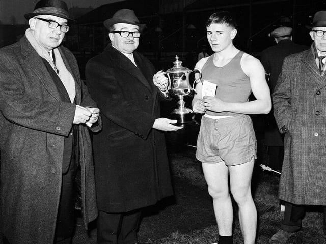 Mr J Harris presents the cup to D Hendrie, the winner of the youth 100 yards handicap at the Powderhall New Year Sprint in 1965.