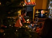 A family sits in a living room in Liverpool, as they watch Britain's King Charles III delivering his first annual Christmas Day message, on television. Picture: Paul Ellis/AFP via Getty Images