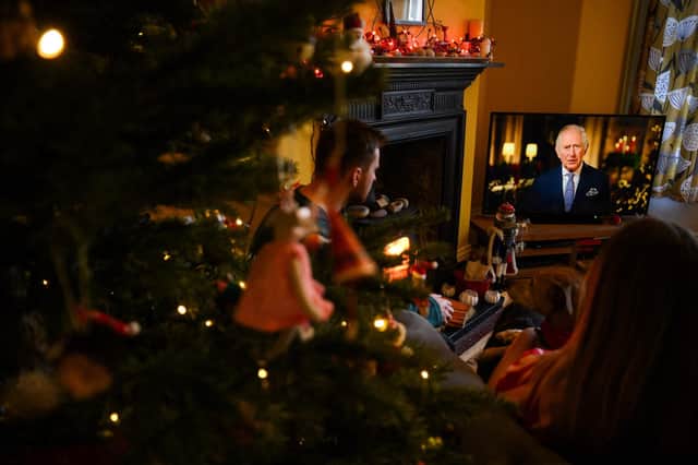 A family sits in a living room in Liverpool, as they watch Britain's King Charles III delivering his first annual Christmas Day message, on television. Picture: Paul Ellis/AFP via Getty Images