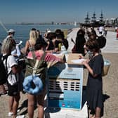 Tourists wear protective face masks as they fill in a form for before embarking on as small cruise boat along the waterfront of the northern city Greek  of Thessaloniki.  (Photo by SAKIS MITROLIDIS/AFP via Getty Images)