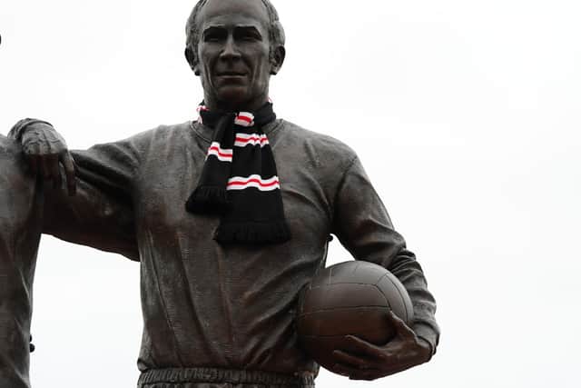 A general view of the statue of Sir Bobby Charlton decorated with a scarf at Old Trafford.