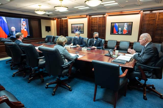 In this image released by The White House, US President Joe Biden (R), with Secretary of State Antony Blinken (2nd R) speaks with Russian President Vladimir Putin (on screen) from the White House in Washington, DC, on December 7, 2021. (Image credit: HANDOUT/The White House/AFP via Getty Images)