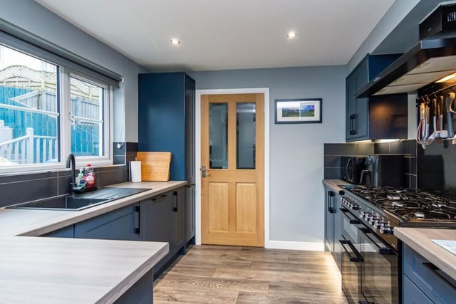 The kitchen has contemporary units, wood-effect worktops, a composite sink, range cooker, and integrated dishwasher.