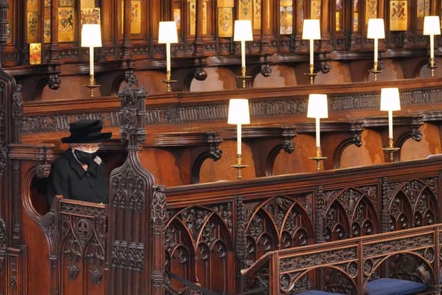 The Queen pictured sitting alone in St George's Chapel at Prince Philip's funeral