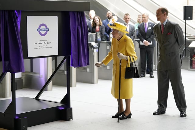 Queen Elizabeth II unveils a plaque whilst the Earl of Wessex watches to mark the Elizabeth line's official opening at Paddington station in London, to mark the completion of London's Crossrail project.