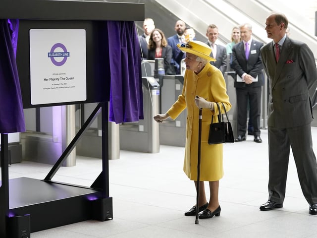 Queen Elizabeth II unveils a plaque whilst the Earl of Wessex watches to mark the Elizabeth line's official opening at Paddington station in London, to mark the completion of London's Crossrail project.