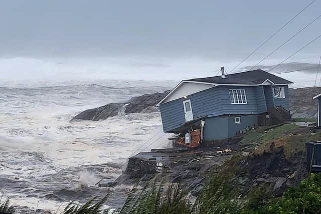 In this photo provided by Wreckhouse Press a home fights against high winds caused by post Tropical Storm Fiona in Port aux Basques, Newfoundland and Labrador, Saturday, Sept. 24, 2022. The home has since been lost at sea. (Rene Roy/Wreckhouse Press via The Canadian Press via AP)