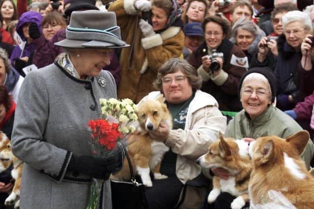 Queen Elizabeth II talks with members of the Manitoba Corgi Association during a visit to Winnipeg in October 2002.
