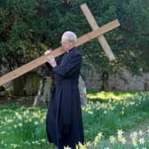 The Archbishop of Canterbury Justin Welby carries a wooden cross during the Walk of Witness at St Mary's Church, Sellindge, Kent, as he carries out his Holy Week engagements.