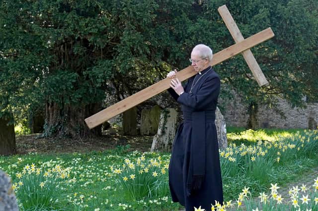 The Archbishop of Canterbury Justin Welby carries a wooden cross during the Walk of Witness at St Mary's Church, Sellindge, Kent, as he carries out his Holy Week engagements.