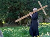 The Archbishop of Canterbury Justin Welby carries a wooden cross during the Walk of Witness at St Mary's Church, Sellindge, Kent, as he carries out his Holy Week engagements.