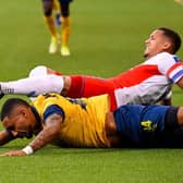 Rangers' English defender James Tavernier and Saint-Gilloise's French-Malagasy forward Loic Lapoussin fall during the UEFA Champions League third qualifying round first leg  match between Rangers and Royale Union Saint-Gilloise at the "Den Dreef Stadium" in Heverlee.  (Photo by LAURIE DIEFFEMBACQ/BELGA/AFP via Getty Images)