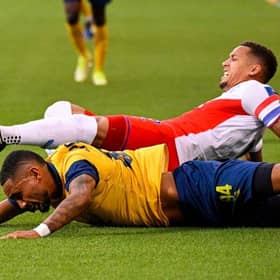 Rangers' English defender James Tavernier and Saint-Gilloise's French-Malagasy forward Loic Lapoussin fall during the UEFA Champions League third qualifying round first leg  match between Rangers and Royale Union Saint-Gilloise at the "Den Dreef Stadium" in Heverlee.  (Photo by LAURIE DIEFFEMBACQ/BELGA/AFP via Getty Images)