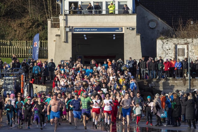 Over one hundred people take part in the Kinghorn Loony Dook New Years Day swim on the Fife coast of the Firth of Forth