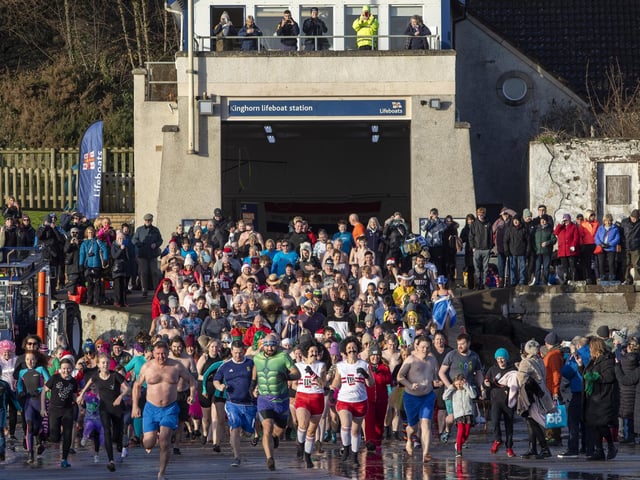 Over one hundred people take part in the Kinghorn Loony Dook New Years Day swim on the Fife coast of the Firth of Forth