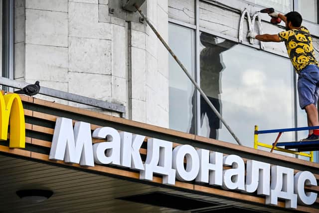 A worker removes McDonald's logotype from a restaurant in Moscow last year.