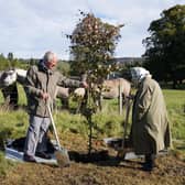 Queen Elizabeth and Prince Charles plant a tree to mark the start of the official planting season for the Queen's Green Canopy at the Balmoral Cricket Pavilion (Picture: Andrew Milligan/pool/AFP via Getty Images)