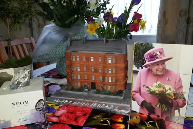 The special tenement cake takes pride of place next to the couple's 60th anniversary card from the Queen.
