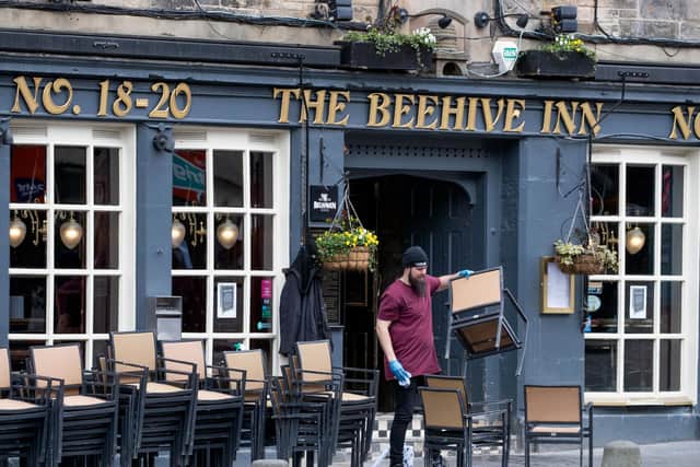 A member of staff at The Beehive Inn in the Grassmarket, Edinburgh, cleans and puts away the chairs following the pub's closure due to the coronavirus outbreak.