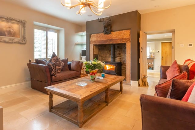 The charming lounge has feature inglenook style fireplace with wood burning stove and an Italian limestone tiled floor with underfloor heating.
