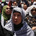 An elderly Palestinian woman lifts a national flag during a rally marking Nakba day in the Ramallah city centre in the occupied West Bank last year.