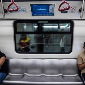 A television (top) on a train in Hong Kong on August 5, 2022, shows military exercises being held by China around the island of Taiwan. (Photo by ISAAC LAWRENCE / AFP) (Photo by ISAAC LAWRENCE/AFP via Getty Images)