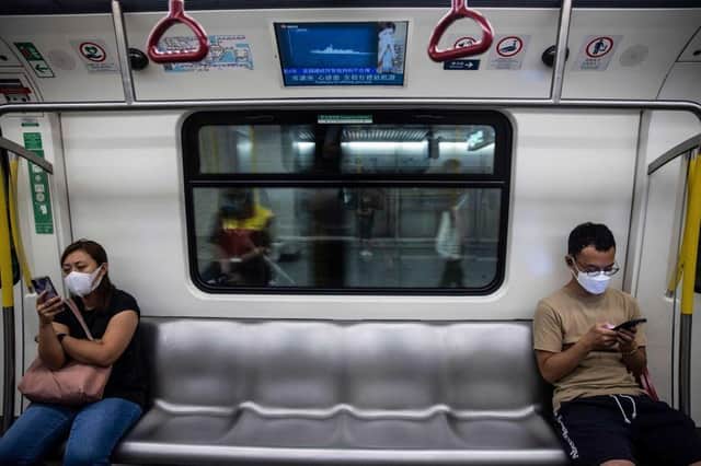 A television (top) on a train in Hong Kong on August 5, 2022, shows military exercises being held by China around the island of Taiwan. (Photo by ISAAC LAWRENCE / AFP) (Photo by ISAAC LAWRENCE/AFP via Getty Images)