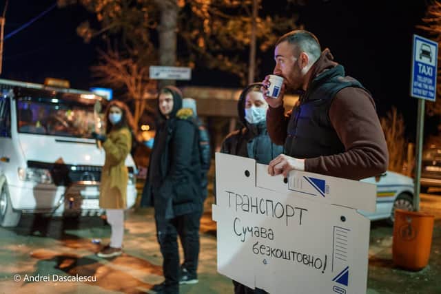 Romanian volunteers hold up signs in Ukrainian offering help to refugees as they arrive. Picture: Andrei Dascalescu