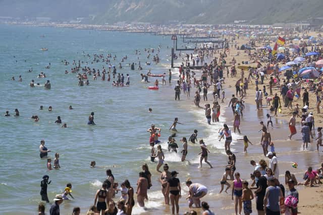 People enjoying the warm weather on Bournemouth beach in Dorset. The boom of cheap package holidays in the 1960s has been linked to a rise in a serious type of skin cancer among older adults, charity Cancer Research UK has suggested. Picture: Andrew Matthews/PA Wire