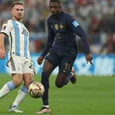 Argentina's midfielder Alexis Mac Allister fights for the ball with France's forward Ousmane Dembele.