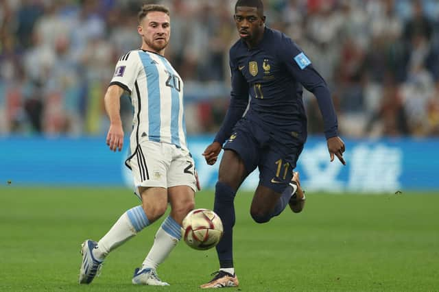 Argentina's midfielder Alexis Mac Allister fights for the ball with France's forward Ousmane Dembele.