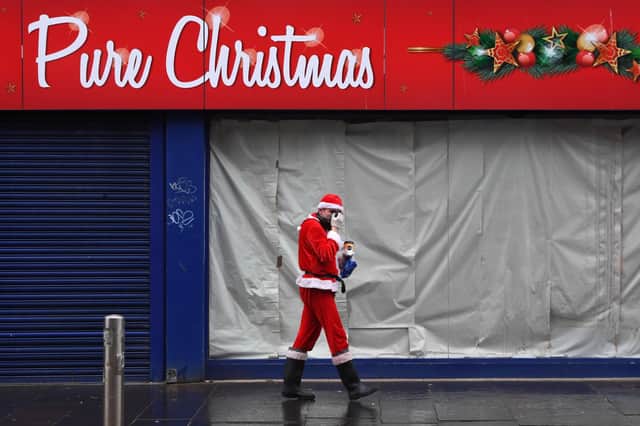 Santa Claus, or someone dressed as him, grabs a coffee in central Glasgow as he and the nation await to hear what kind of festivities will be allowed (Picture: Andy Buchanan/AFP via Getty Images)
