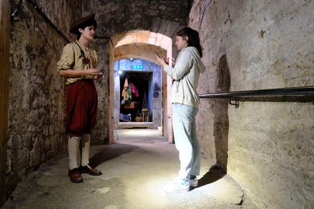 A visitor using The Real Mary King's Close BSL Guide during a tour