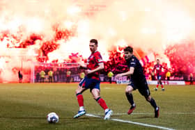 Rangers' Ryan Jack and Dundee's Owen Beck in action as flares fill the stand behind them.  (Photo by Ross Parker / SNS Group)
