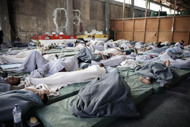 Suvivors rest in a warehouse used as a temporary shelter, after the tragic boat accident of the coast of Greece.