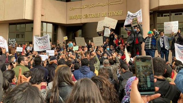 Protesters on the streets of Tunis stop outside the Central Bank  of Tunisia